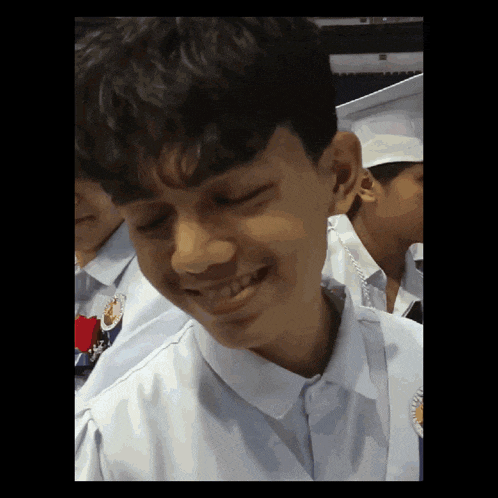 a young man in a graduation cap and gown smiles