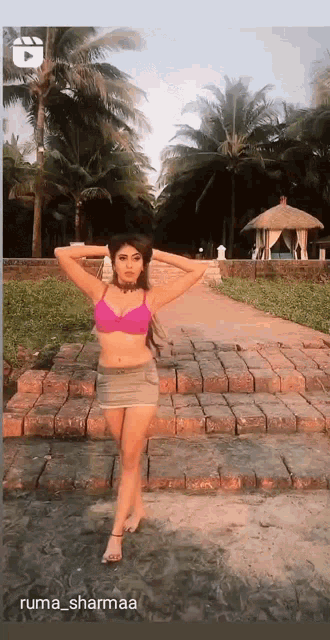 a woman in a bikini is standing on a brick path