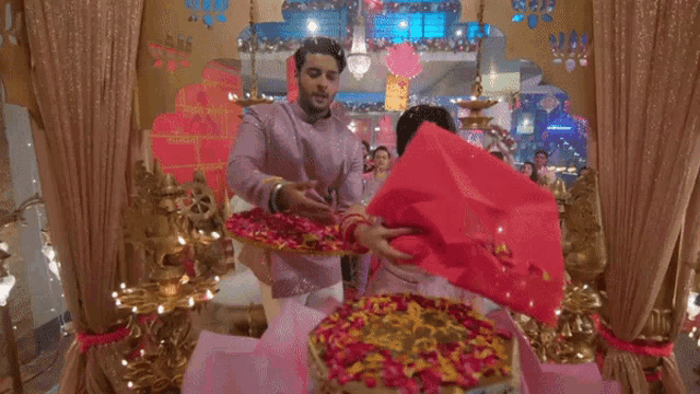 a man and a woman are standing in a room with flowers and a sign that says ' shree ' on it