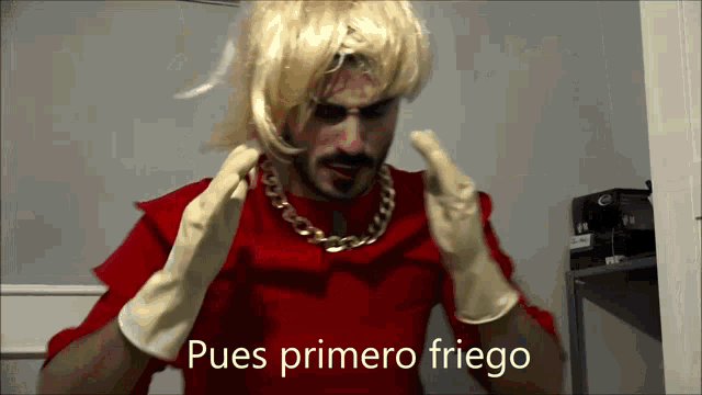 a man wearing a wig and rubber gloves says " pues primero friego "