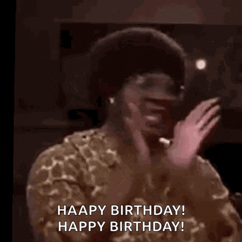 a woman in a giraffe print shirt is waving her hand and saying `` happy birthday ! happy birthday ! ''
