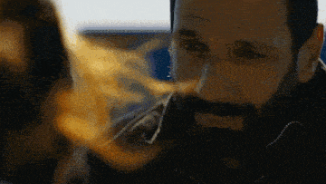 a man with a beard is smiling and looking at a woman