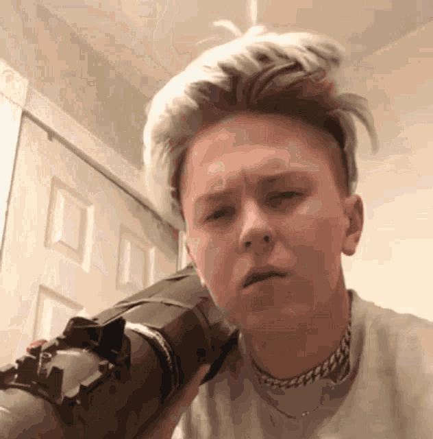 a young man is holding a gun in his hand and making a funny face