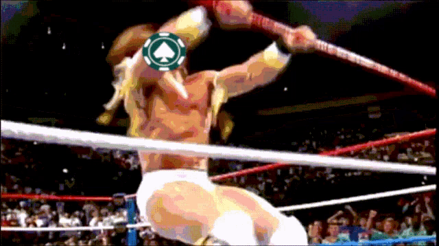 a man in a wrestling ring has a poker chip on his head