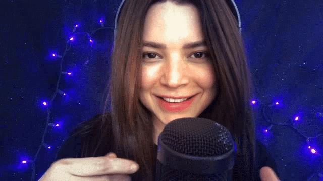a woman wearing headphones is playing with a microphone .