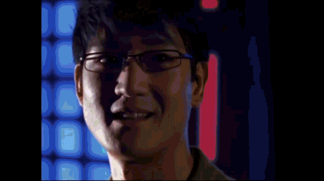 a man wearing glasses and a green shirt is making a funny face .