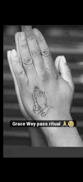 a tattoo of praying hands on a person 's hand