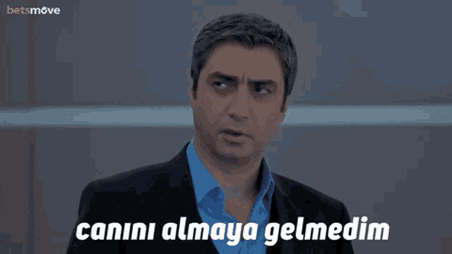 a man in a suit and blue shirt with the words soruma cevap almaya geldim