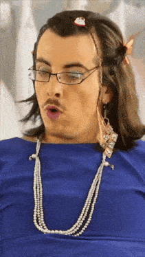 a man wearing glasses and a pearl necklace is making a funny face