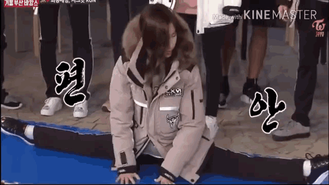 a girl is doing a split on a blue mat with chinese writing on the bottom