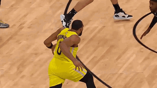 a basketball player wearing a yellow jersey with jazz on it