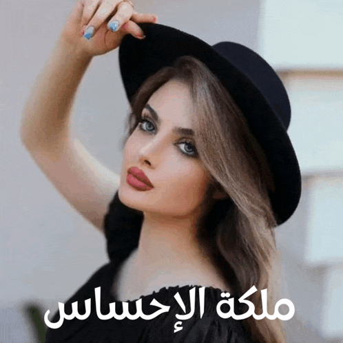 a woman wearing a black hat has arabic writing on the bottom