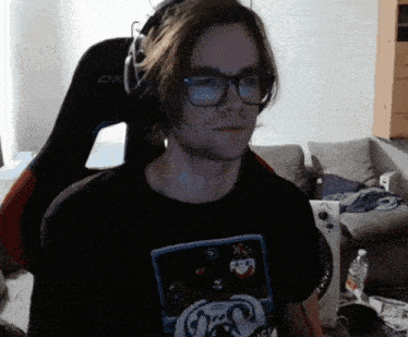 a man wearing glasses and headphones is sitting in a gaming chair