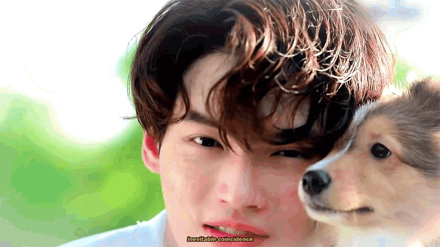 a close up of a man holding a small dog with the words inevitable coincidence written on the bottom