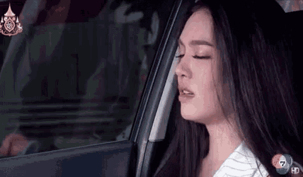 a woman is sitting in the back seat of a car with her eyes closed and her mouth open .