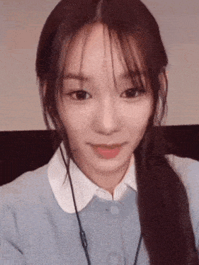 a close up of a girl wearing headphones and a blue sweater .