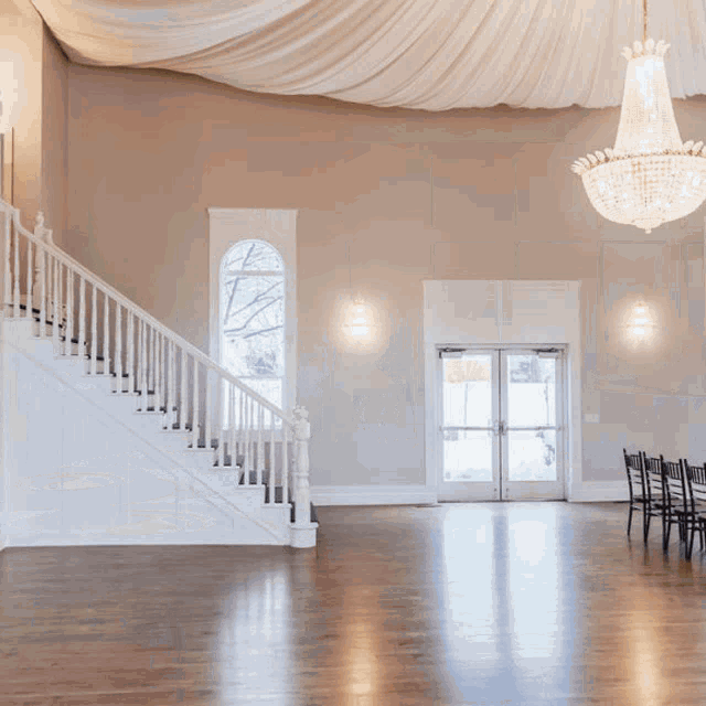 an empty room with a staircase and a chandelier