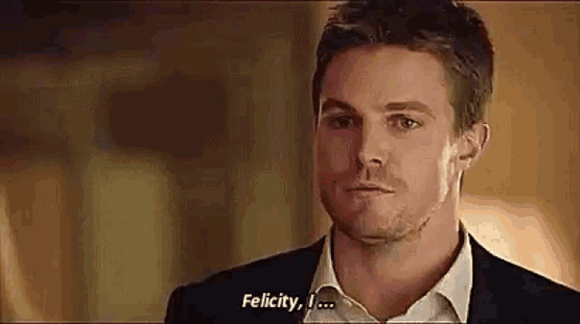 a man in a suit and white shirt is talking to another man and says `` felicity , i ... '' .