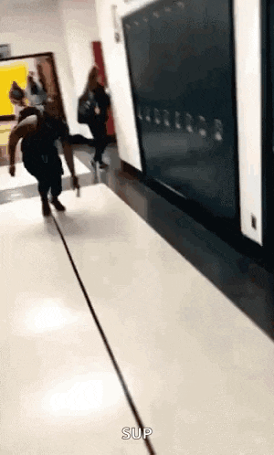 a man is running down a hallway in a school .