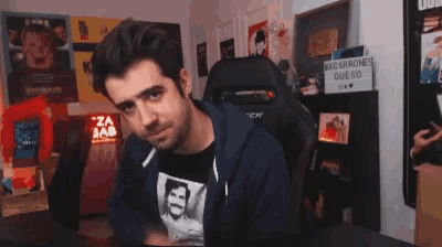 a man is waving his hand while sitting in a gaming chair .