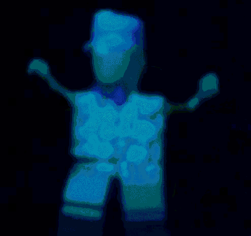 a cartoon character wearing a green hat and a yellow shirt is dancing in the dark .