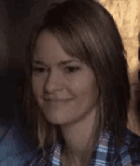 a close up of a woman wearing a plaid shirt and smiling .