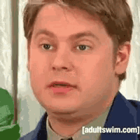 a close up of a man 's face with the words adultswim.com written on the bottom .
