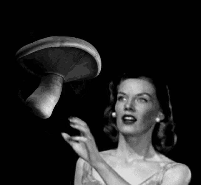 a woman throws a mushroom in the air in a black and white photo