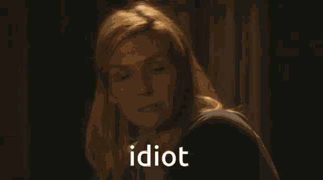 a woman with blonde hair is looking at the camera with the word idiot above her