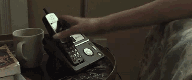 a woman is sitting on a couch talking on a phone .