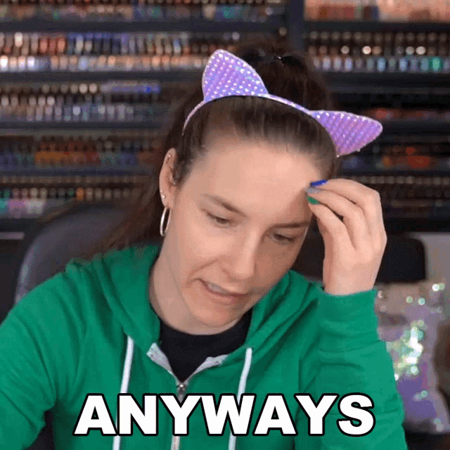 a woman wearing a cat ear headband and a green hoodie says " anyways "