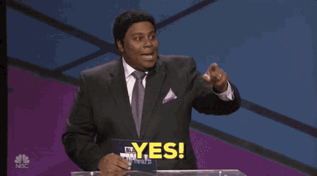 a man in a suit and tie stands at a podium and says yes