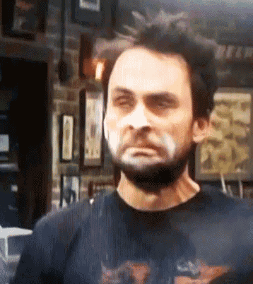 a man with a beard is wearing a black shirt with a motorcycle on it