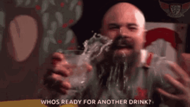 a bald man with a beard is holding a glass of water in front of his face and says whos ready for another drink