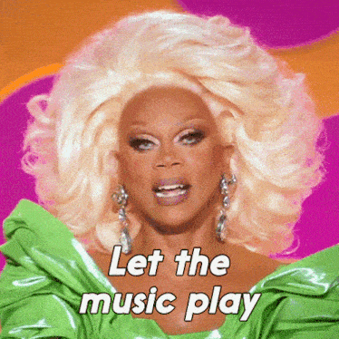 a drag queen says let the music play while wearing a green top