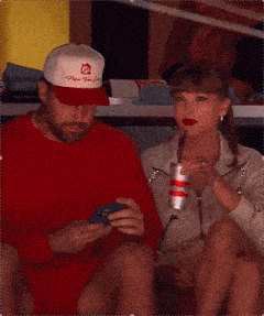 a man and a woman are sitting next to each other and the man is wearing a hat that says washington redskins