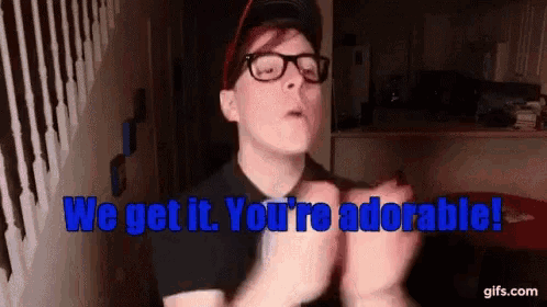 a man wearing glasses and a hat says we get it you 're adorable
