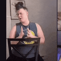 a man is sitting in a chair with a batman shirt on .