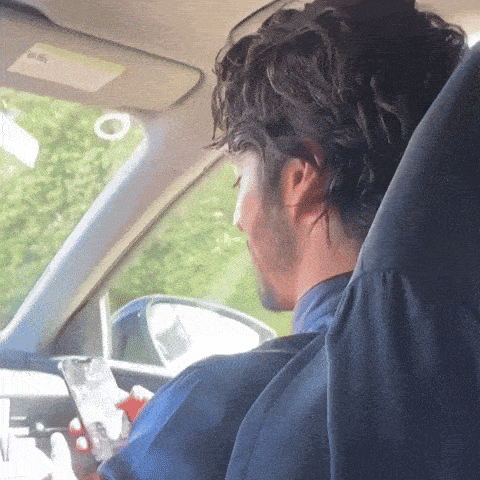 a man sitting in a car with a sticker on the visor that says ' airbag ' on it
