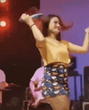 a woman is singing into a microphone on a stage .