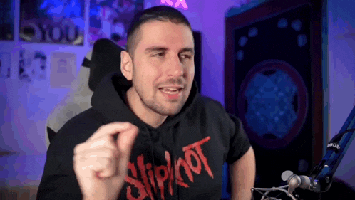a man wearing a slipknot hoodie is giving a thumbs up