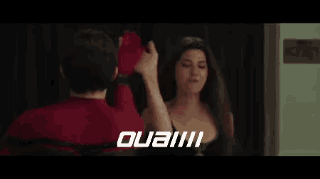 a man and woman are giving each other a high five .