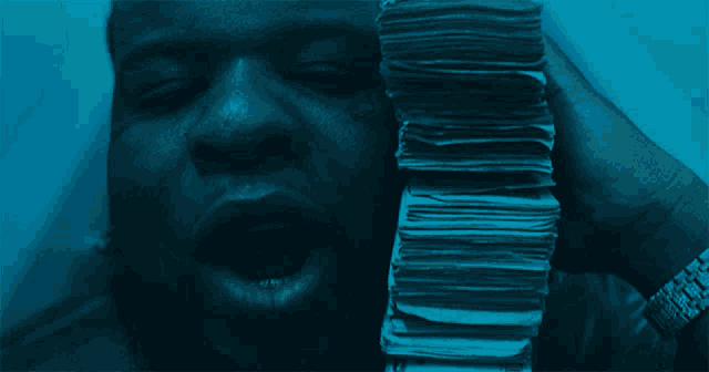 a man is holding a stack of money with his mouth open