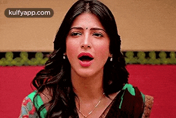 a woman is making a funny face with her mouth wide open .