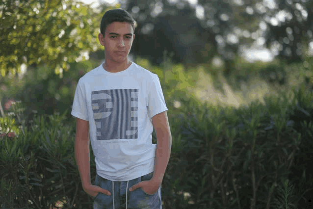 a young man wearing a white t-shirt with the letter p on it