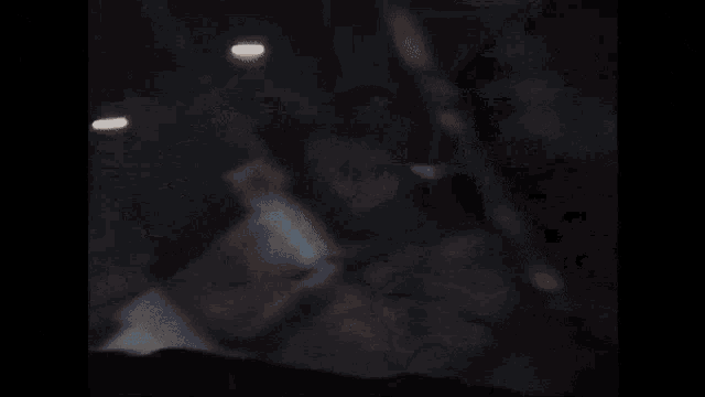 a man in a suit stands in a dark cave with a flashlight