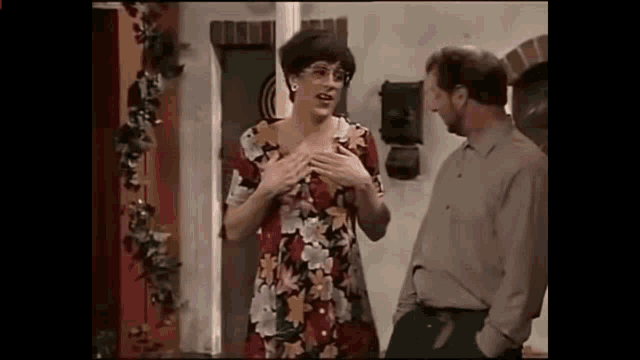 a man and a woman are standing next to each other in a room .