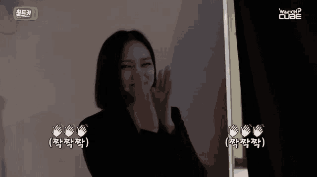 a woman applauds in front of a screen that says hungry cube on it