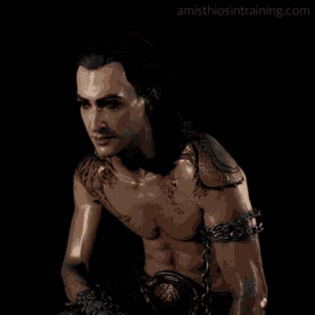 a statue of a shirtless man with chains around his arms and a website called amisthiosintraining.com