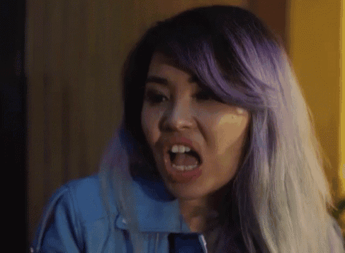 a woman with purple hair has her mouth open